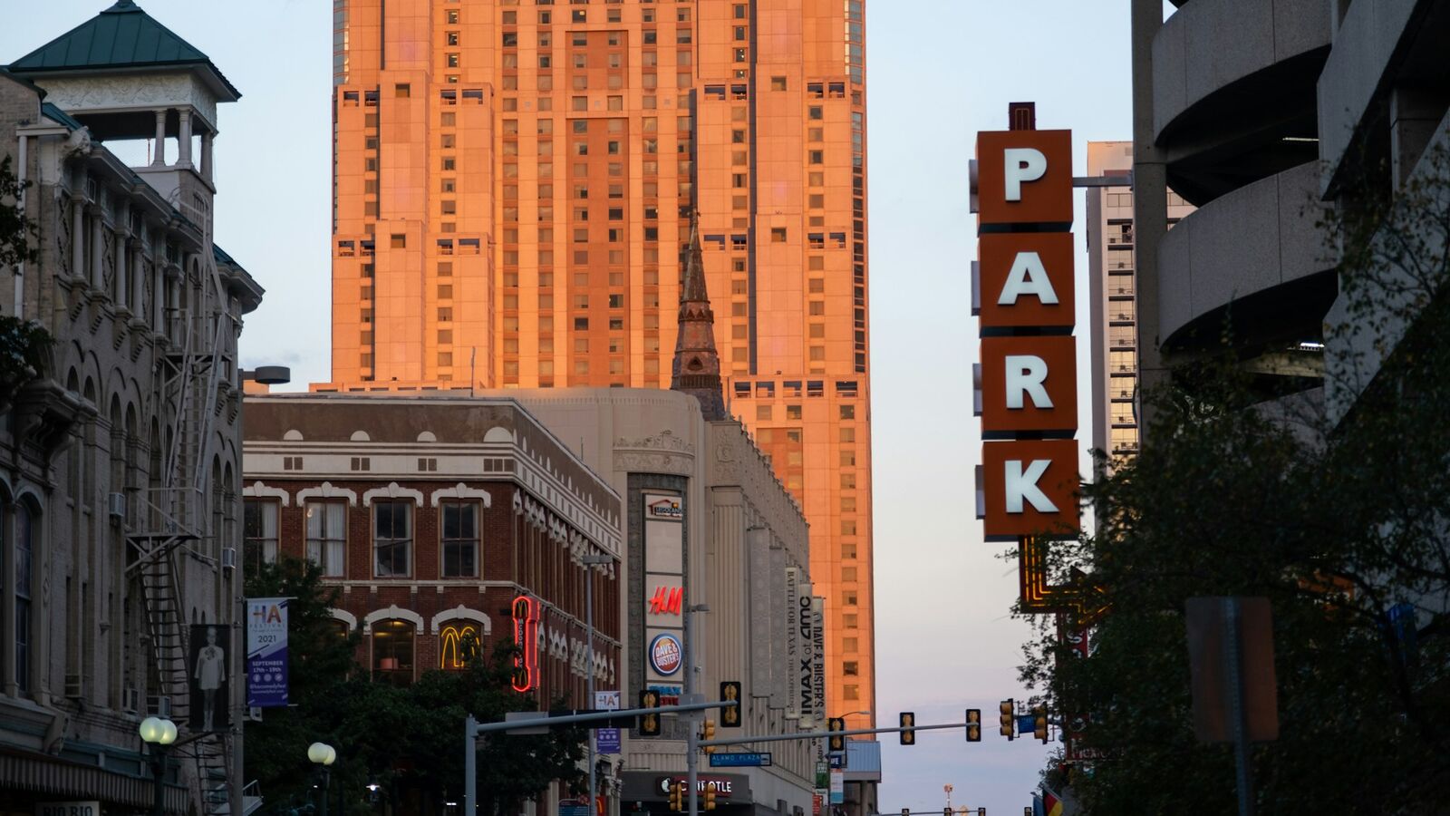 Parking garage sign among towers in downtown San Antonio at dusk