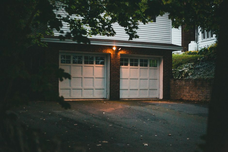 Two-car garage under a lit lamp at dusk