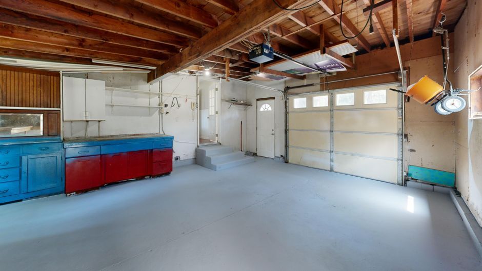 Empty residential garage interior with storage cabinets