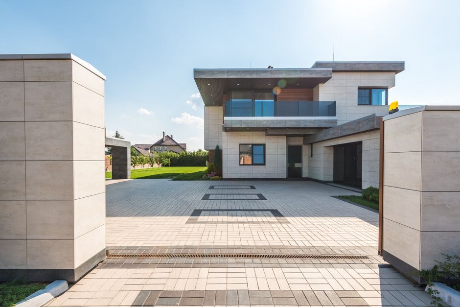 Gated entry opening onto a paved private driveway