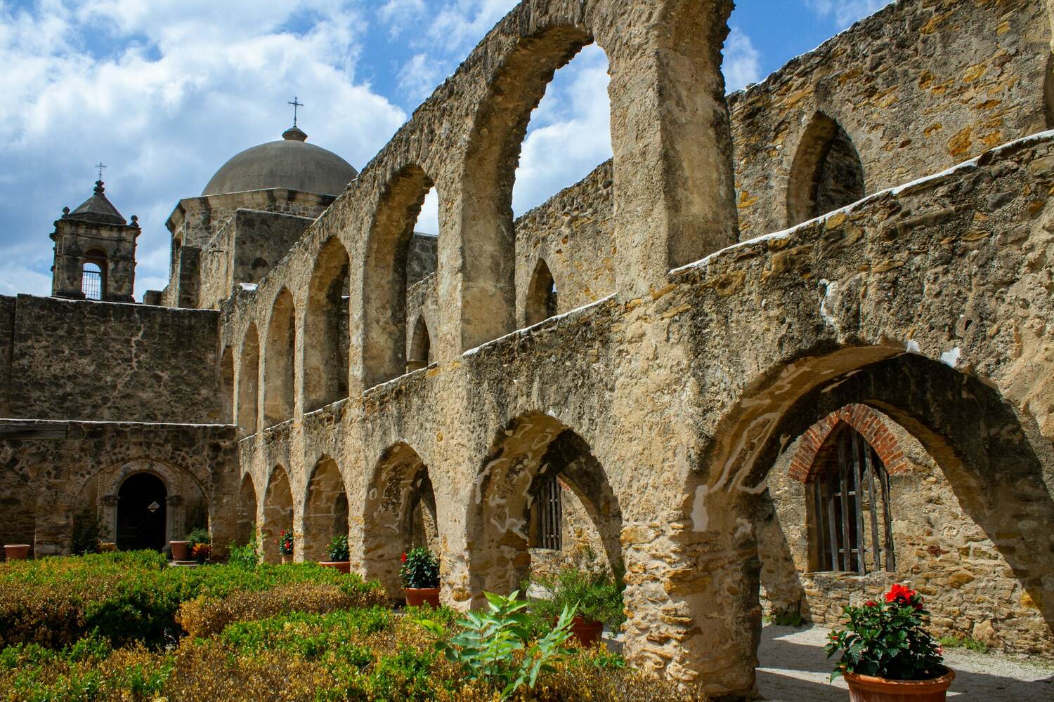 Stone arches and courtyard garden at a San Antonio mission