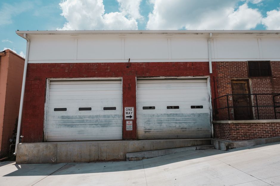 White roller doors on a brick commercial building